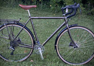 A brown bike is parked in the grass.