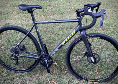 A black bike is parked in the grass.
